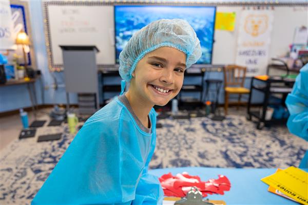 girl in scrubs smiling in classroom